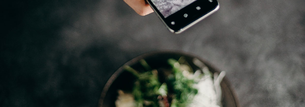 femme prenant une photo d'un plat avec un smartphone